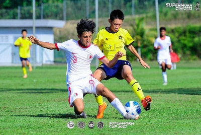 Pemain Hong Kong FA (kiri) mengasak pemain Evergrande Football dalam aksi Kategori Bawah 13 Tahun Kejohanan Supermokh 2023 di padang AMD Gambang, Pahang. Foto: National Football Development Programme - NFDP