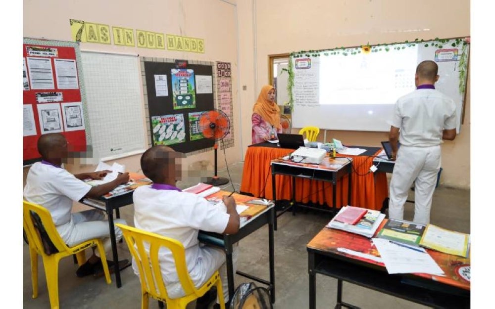 Osman (berdiri, kanan) mengikuti sesi pembelajaran di Sekolah Integriti Pusat Koreksional Puncak Alam.