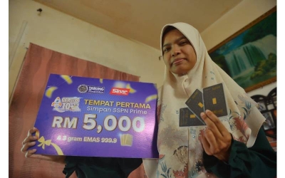 Nurul Syahadah menunjukkan hadiah wang tunai dan kepingan emas yang diterimanya sebagai pemenang Peraduan Genius IQ anjuran PTPTN.