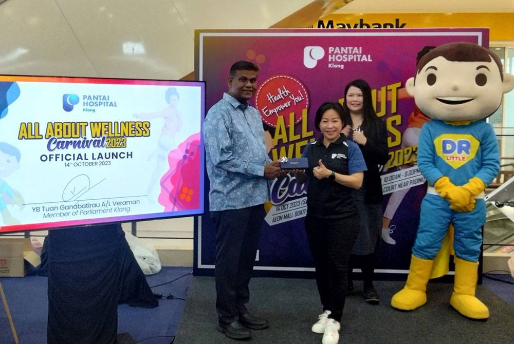 Rachel (kanan) menyampaikan cenderahati kepada Ganabatirau selepas majlis perasmian.