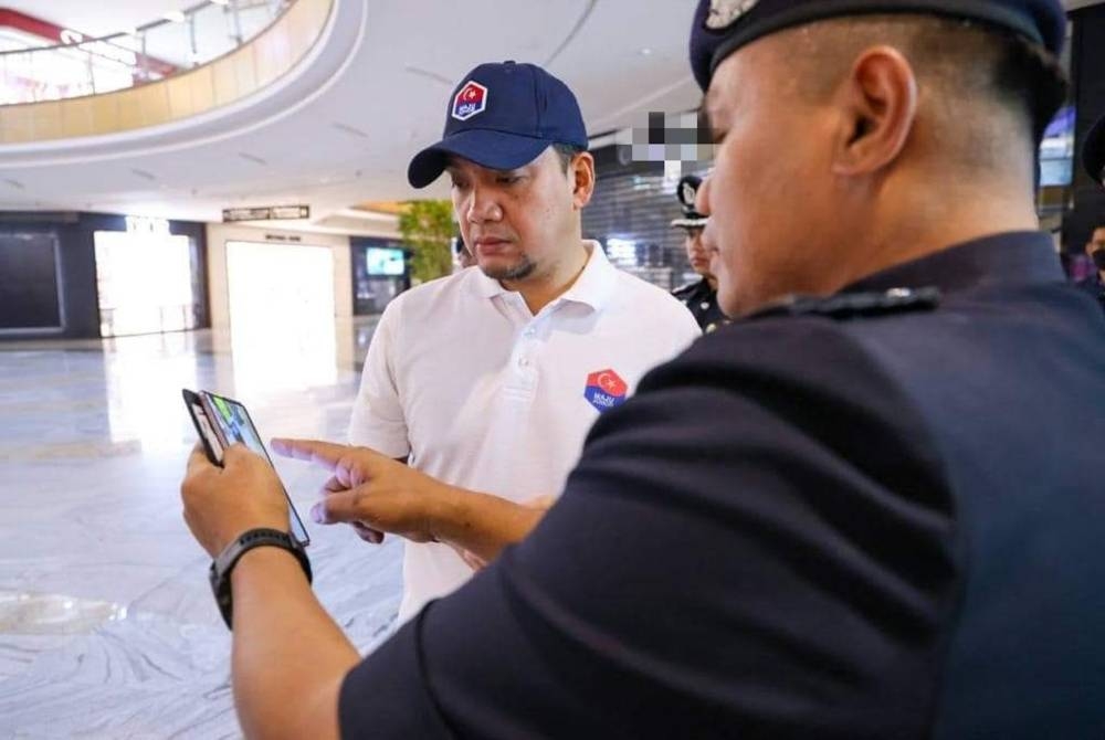 Onn Hafiz ( kiri) diberikan penerangan mengenai situaai terkini pusat beli belah yang menerima ancaman bom panggilan palsu.