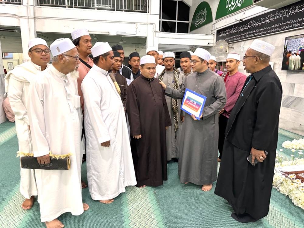 Adnan (kanan) dan Muhammad (dua dari kanan) beramah mesra dengan Muhammad Qayyim Nizar (tiga dari kanan) serta peserta Program Belia #QuranHour. 