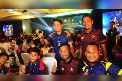 Adam (berdiri, kiri) bersama pegawai dan pemain pada majlis makan malam sempena kejohanan Piala Supermokh 2023 di Gambang pada malam Sabtu.