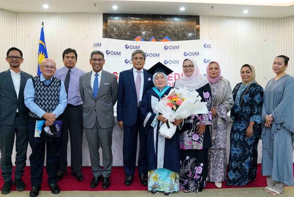 Normah Hanum (lima dari kanan) bergambar bersama ahli keluarga dan kenalannya selepas Majlis Konvokesyen OUM ke-27 pada Sabtu.