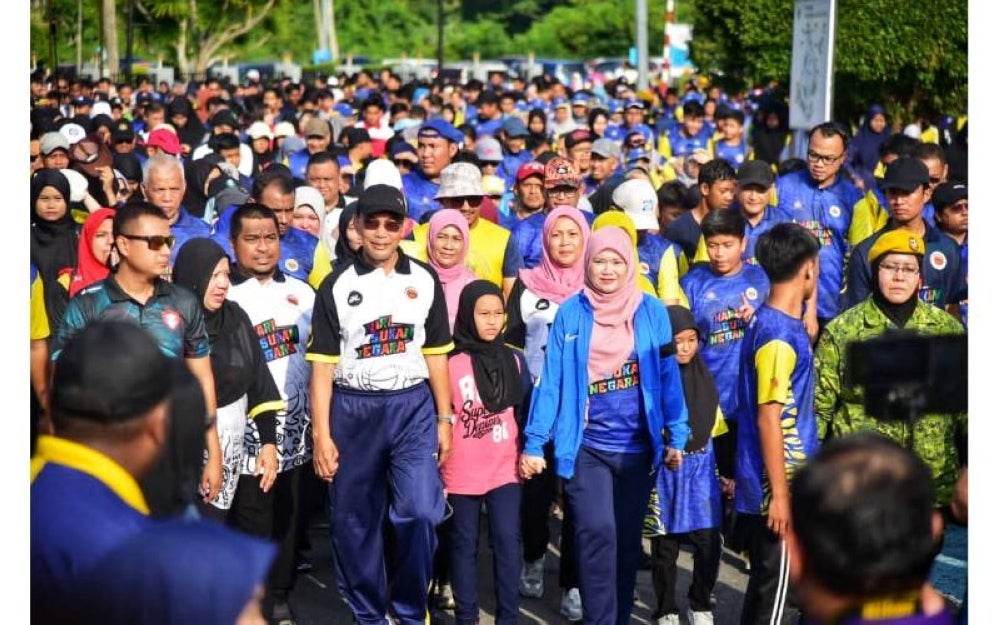 Fadhlina (depan, tengah) bersama Mohd Shukri (bertopi hitam) menyertai Fun Walk ketika Program Kecergasan KPM yang diadakan bersempena HSN 2023 Peringkat Negeri Perlis di Kangar pada Sabtu.
