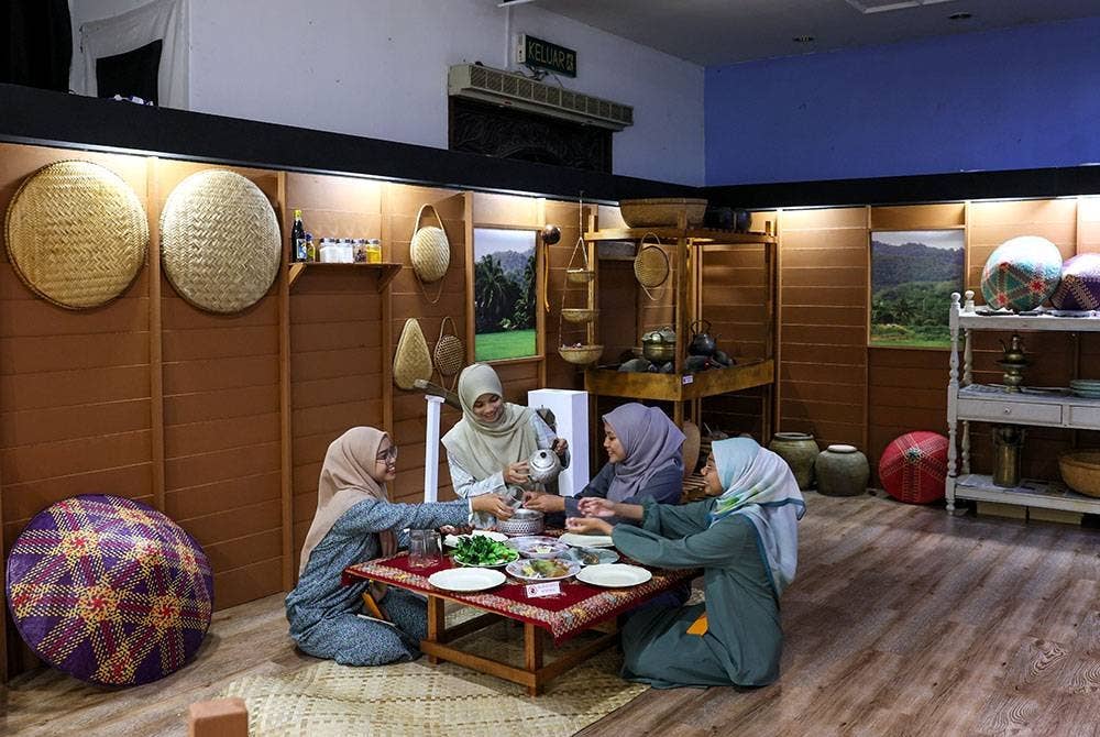 Pelajar Sekolah Menengah Kebangsaan Haji Abdul Rahman Limbong, Nur Fitri Salwa Apiyang@Mohamad, 18, (kiri) bersama rakan-rakan merasai pengalaman berada di dapur zaman dahulu semasa melawat Pameran Dapo Mok Kite: Gastronomi Alam Melayu 2023 di Kompleks Muzium Negeri Terengganu hari ini.