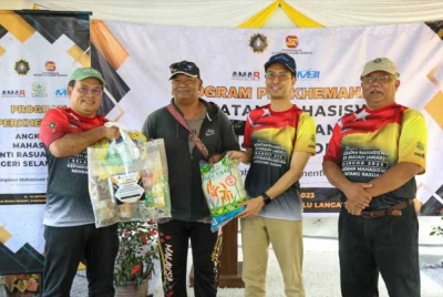 Alias (kanan) mengiringi Raja Ahmad Shahrir (dua dari kanan) menyampaikan bakul integriti kepada salah seorang penerima pada Program Pendidikan Anti Rasuah di Kampung Kuala Pangsun, Hulu Langat pada Sabtu.