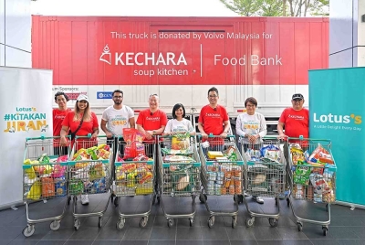 Azliza (lima dari kiri) menyerahkan keperluan harian kepada Kechara Soup Kitchen.