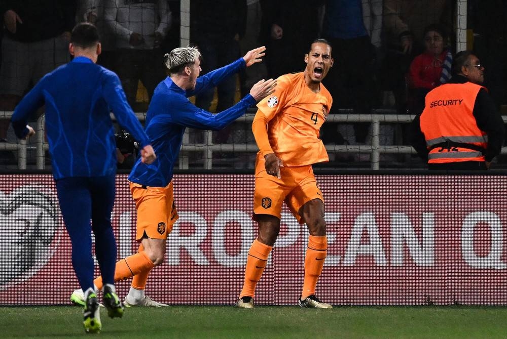Van Dijk (kanan) meraikan jaringannya ketika menentang Greece pada Selasa. - Foto AFP