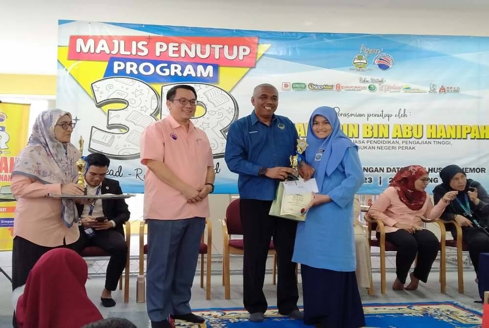 Khairudin (dua dari kanan) menyampaikan hadiah kepada salah seorang pemenang sempena Majlis Penutupan Program 3R @ Perpustakaan Awam Dato' Seri Husni, Chemor pada Selasa.
