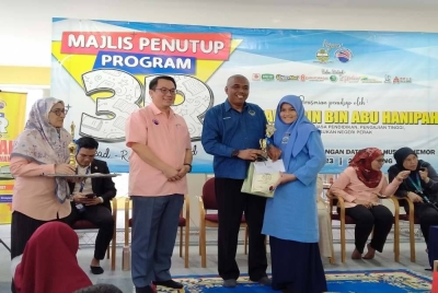Khairudin (dua dari kanan) menyampaikan hadiah kepada salah seorang pemenang sempena Majlis Penutupan Program 3R @ Perpustakaan Awam Dato' Seri Husni, Chemor pada Selasa.