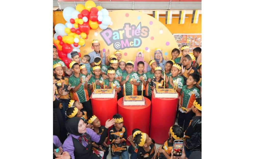Azmir (kiri, belakang) meraikan keceriaan kanak-kanak Yayasan An-Nur Maisarah Chemor yang menyambut hari jadi mereka sempena program Bulan Komuniti McDonald’s.
