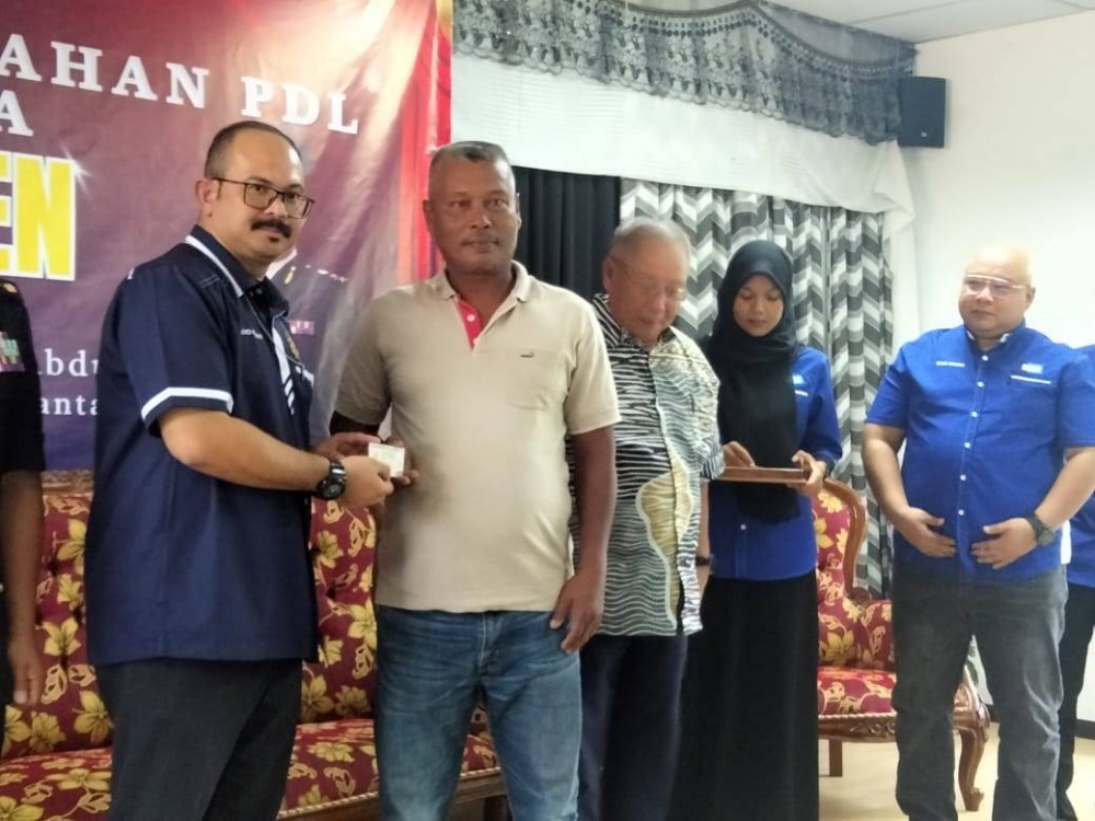 Mohd Misuari (kiri) menyampaikan lesen kepada Zulkifli.