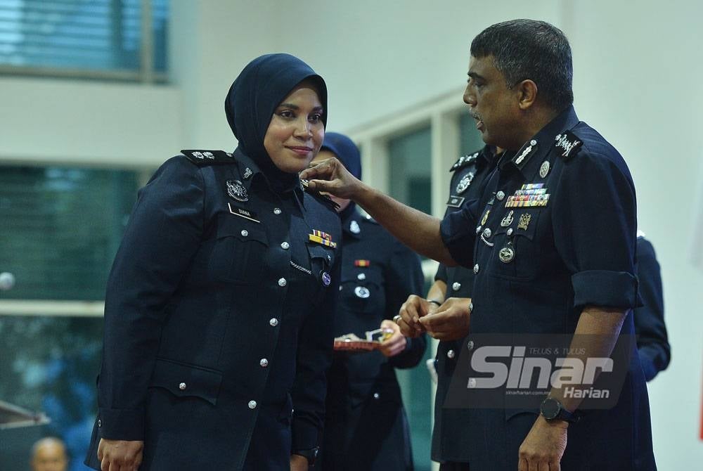 Allaudeen (kanan) memakaikan pangkat kepada salah seorang pegawai polis ketika Majlis Pemakaian Pangkat Pegawai Kanan di Ibu Pejabat Polis Kontinjen Kuala Lumpur di sini pada Rabu. - Foto Sinar Harian/Asril Aswandi Shukor