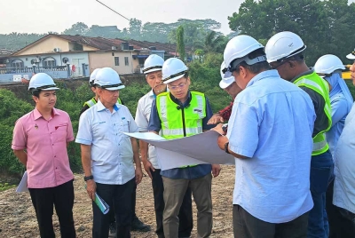 Nik Nazmi (tengah) mendengar penerangan berkenaan
pemulihan saliran di Taman Delima dan Taman Anggerik