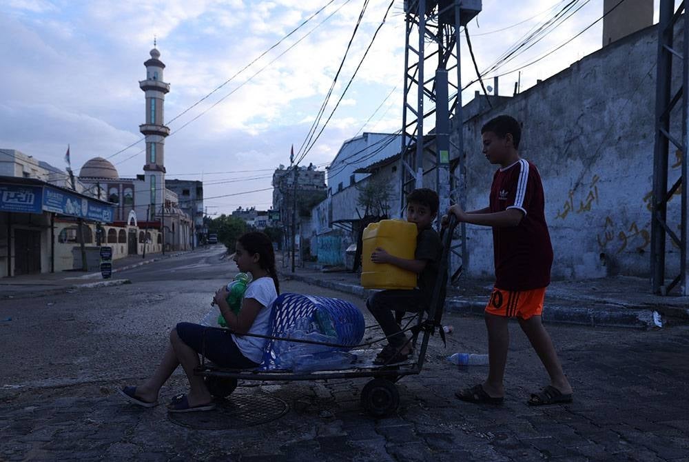 Beberapa kanak-kanak Palestin cuba mencari sumber untuk mendapatkan bekalan air.