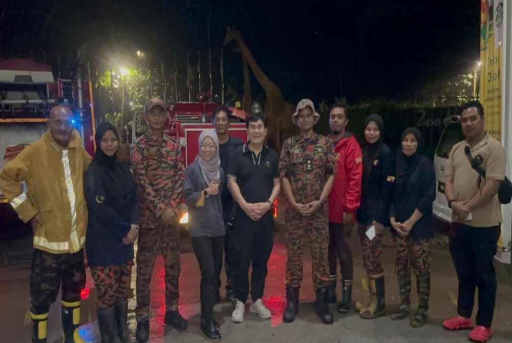 Rosly (lima dari kiri) bersama anggota Balai Bomba Sukareka Gombak dan MPAJ selepas membersihkan Zoo Negara yang dilanda banjir kilat pada Rabu