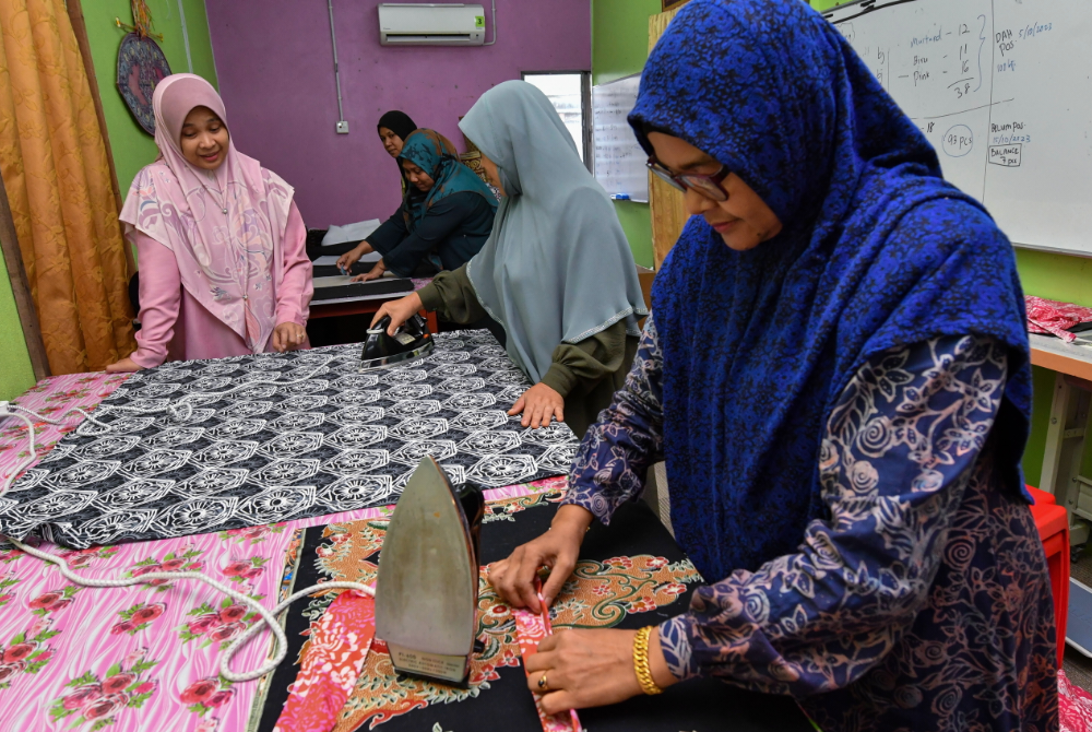 Rozana (kiri) memantau kerja-kerja penghasilan beg bermotifkan batik Kelantan ketika ditemui Bernama di Bengkel Beg Batik Ngesong di Kampung Bukit Chenda, Gunong baru-baru ini. - Foto Bernama