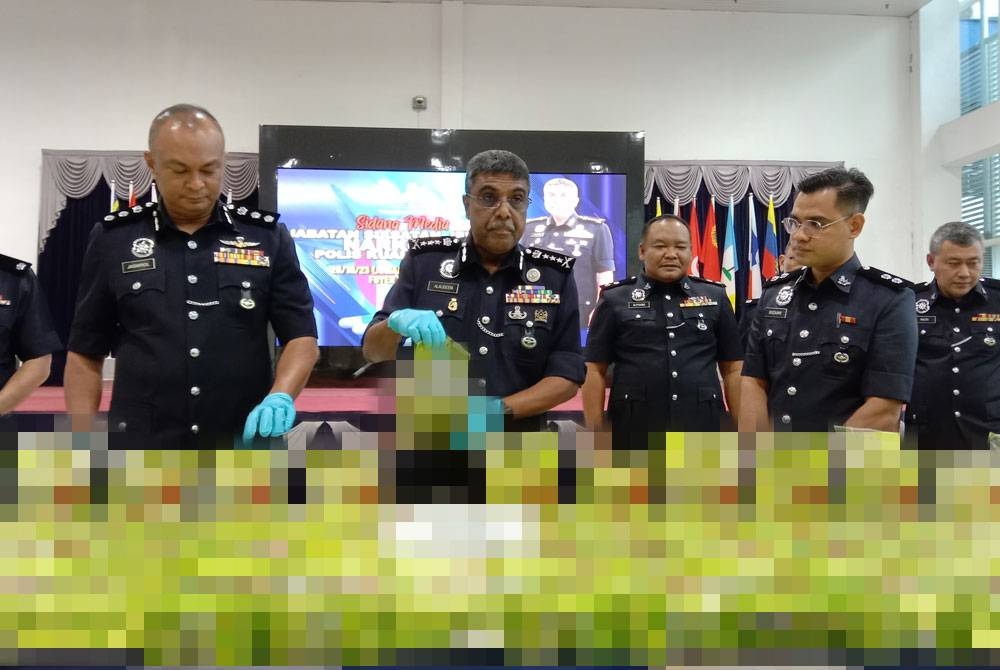 Allaudeen (dua dari kiri) menunjukkan antara bungkusan dadah jenis syabu yang dirampas menerusi serbuan di sebuah gudang di kawasan perindustrian Sri Muda, Shah Alam pada Khamis.