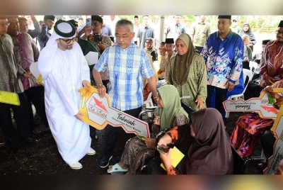 Al-Sultan Abdullah dan Dr Mubarak Saeed Al Dhaheri meyerahkan kunci rumah Ru'Rasa kepada penerima dalam majlis penyerahan di Kampung Pahang Tua di sini pada Jumaat