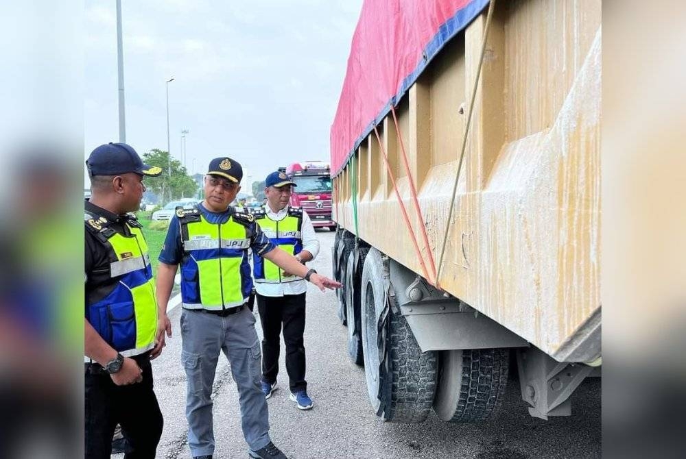 Lokman (tengah) memeriksa lori yang ditahan semasa Op Patuh Khas di sekitar Selangor, baru-baru ini.