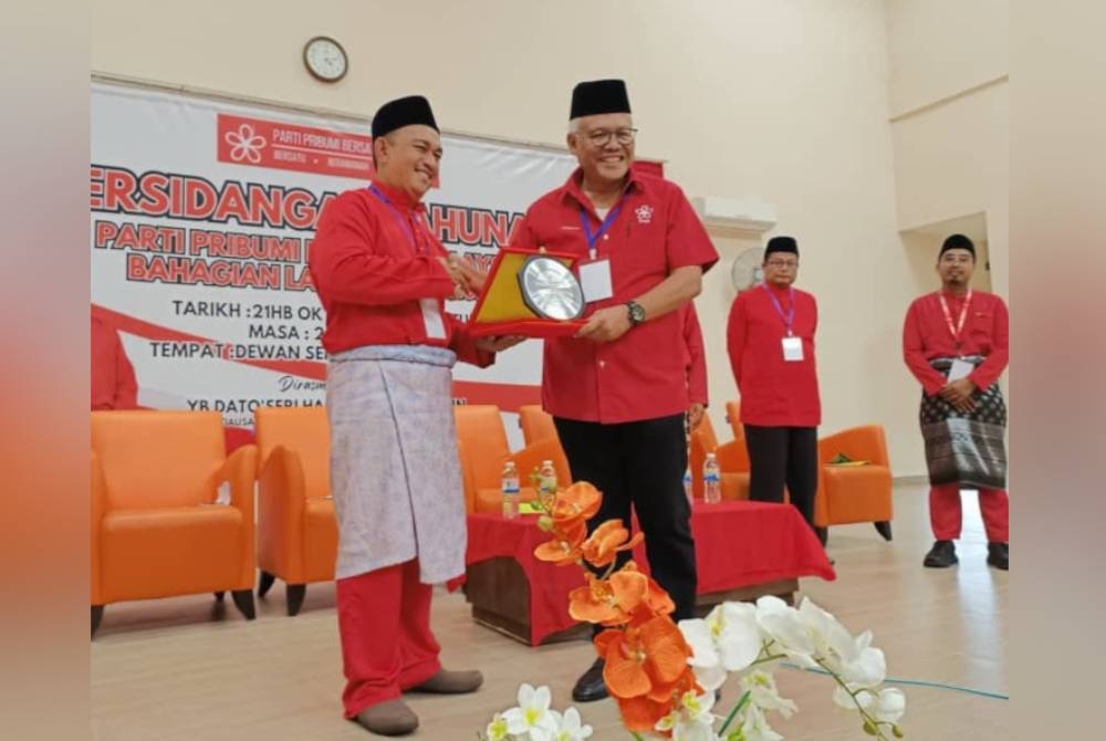 Hamzah (kanan) selepas merasmikan Persidangan Tahunan Bersatu Bahagian Larut di Dewan Semai Bakti Felda Ijok dekat Selama pada Sabtu.