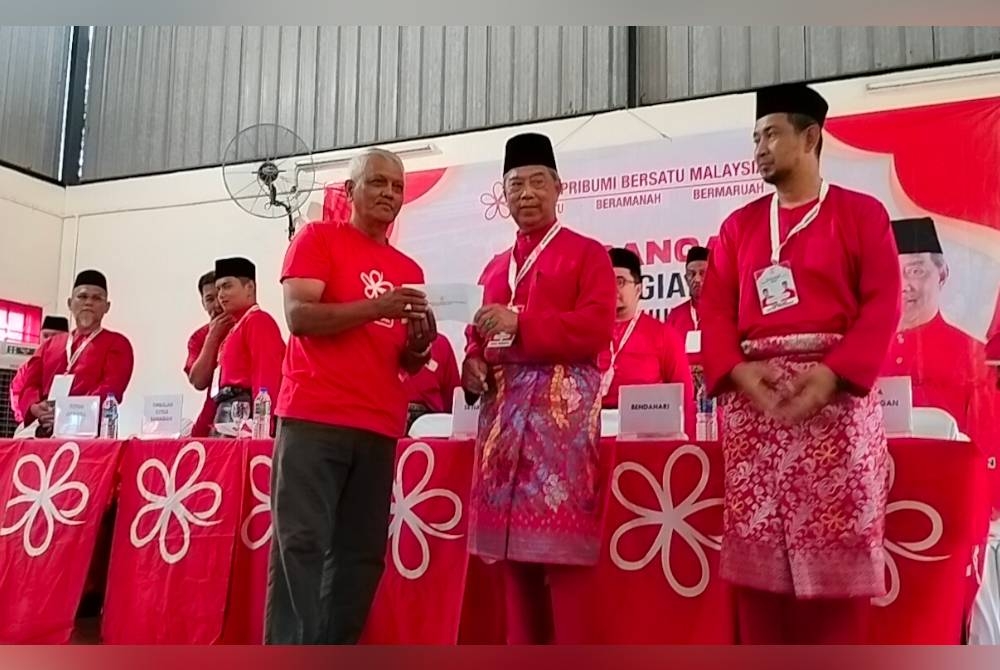 Muhyiddin (dua dari kanan) memberikan sumbangan ketika persidangan Bersatu Bahagian Pagoh di Felda Batu 27 Lenga, Pagoh pada Sabtu.