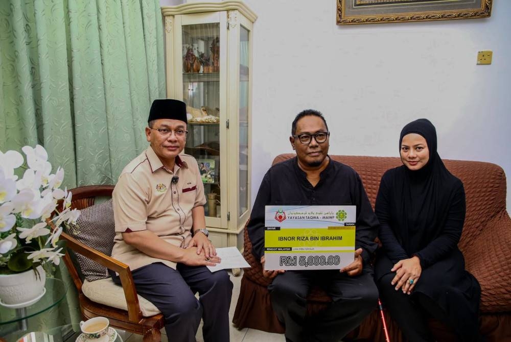 Mohd Na'im (kiri) menyampaikan sumbangan kepada Ibnor (tengah) pada Sabtu.