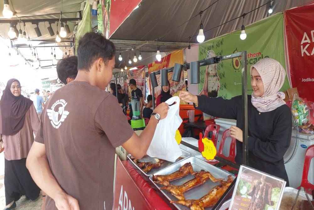 Nur Dania Irdina memberi arnab kangkang kepada pelanggan