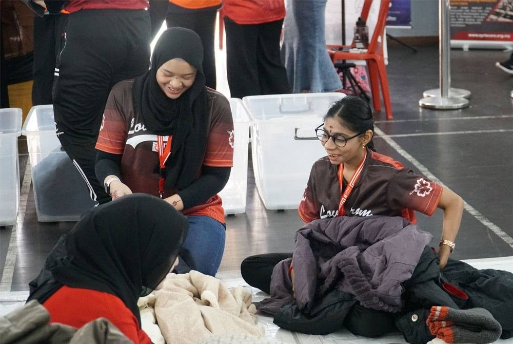 Sukarelawan menyusun atur pakaian musim sejuk untuk di hantar kepada pelarian Syria di Lubnan.