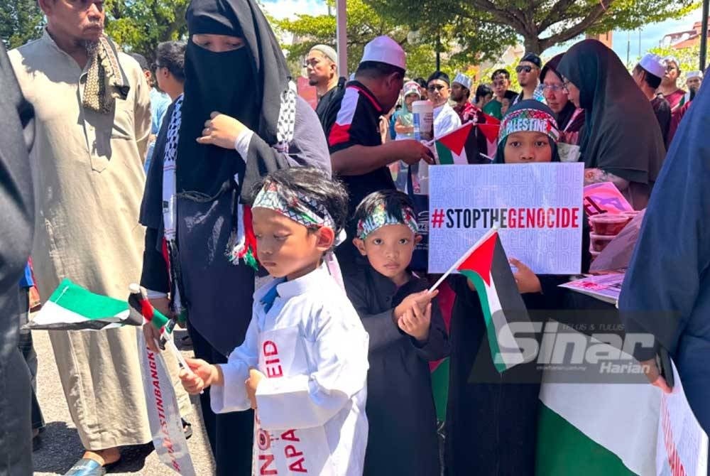 Kanak-kanak memegang sepanduk dengan tanda pagar ‘hentikan pembunuhan beramai-ramai’ pada Himpunan 2 Roda Untukmu Palestin 1.0 (Hiroup) di pekarangan Stadium Sultan Muhammad IV, di sini baru-baru ini.
