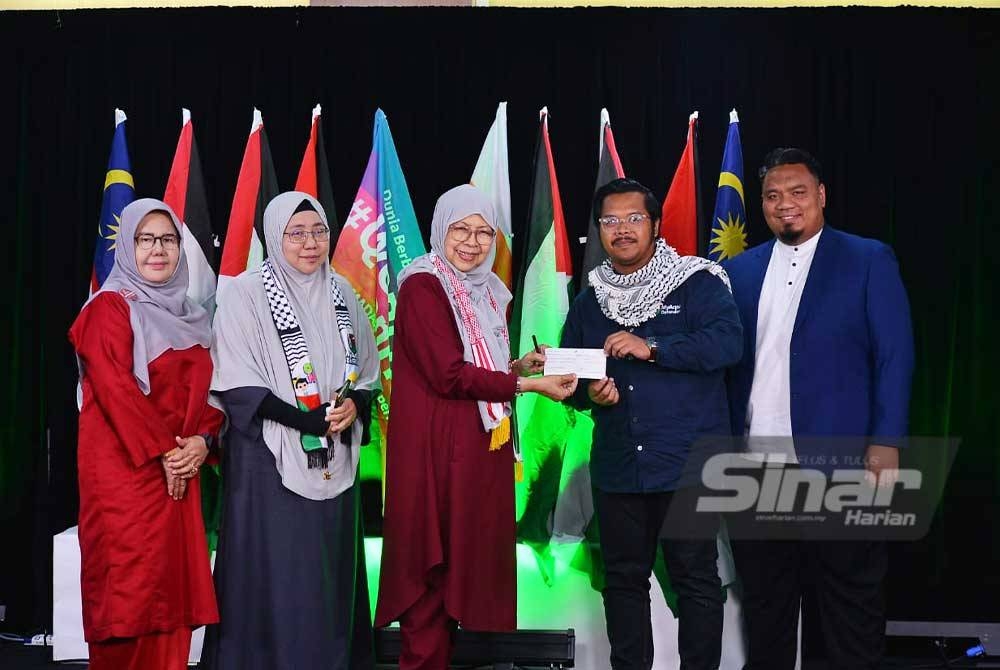 Pengasas Kelab Pesara Muslimah Selangor, Latifah Sidek menyerahkan cek bernilai RM10,000 sumbangan orang ramai kepada CEO MyAqsa Defenders, Aiman Zain. - FOTO SINAR HARIAN/ ASRIL ASWANDI SHUKOR