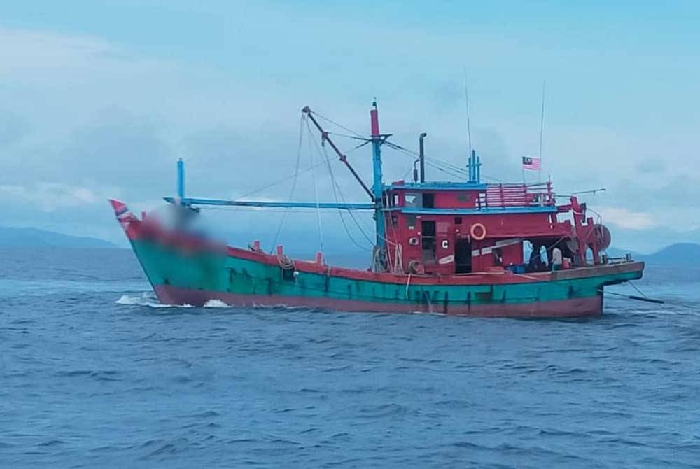Sebuah bot nelayan tempatan kelas C ditahan Maritim Malaysia ketika sedang leka melakukan aktiviti menunda ikan di perairan Langkawi. - Foto: Maritim Malaysia