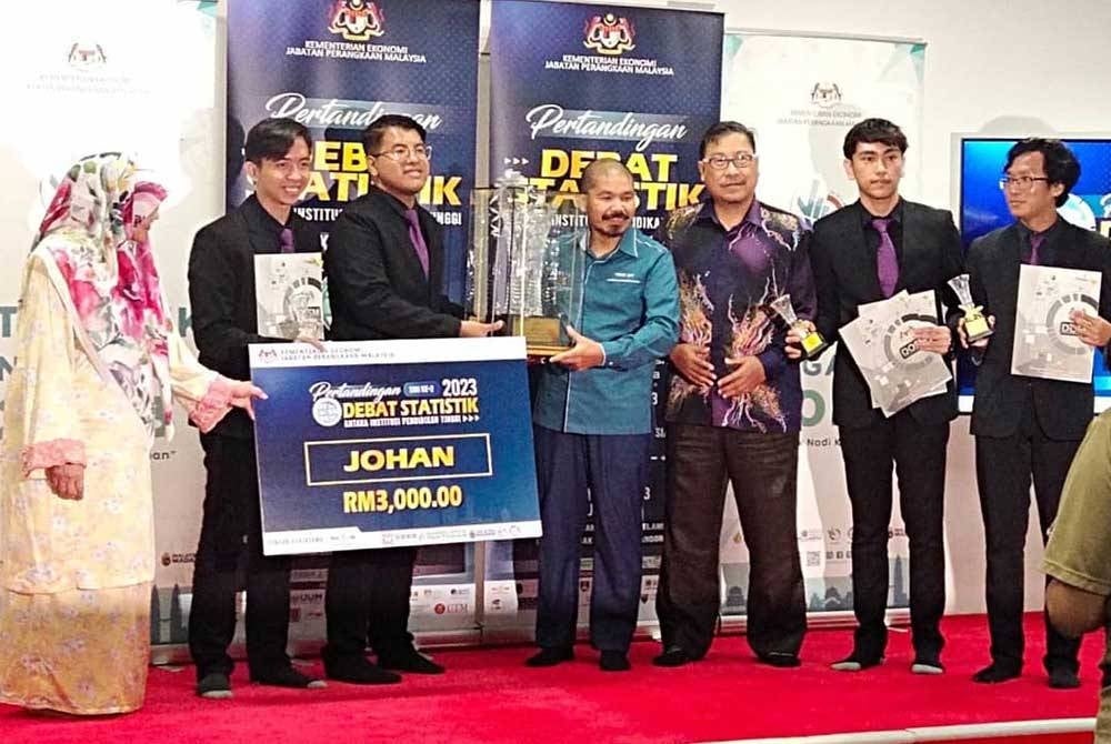 Mohd Uzir (empat dari kanan) menyampaikan hadiah utama Pertandingan Debat Statistik dimenangi peserta dari USM.
