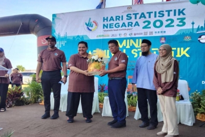 Fareza (dua dari kiri) menerima cenderamata daripada Abdol Samad selepas merasmikan Mini Karnival Statistik Sempena Perayaan Hari Statistik Sedunia pada Sabtu.