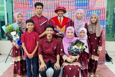 Abdullah (berdiri, tengah) merakam gambar di samping anak dan isteri sempena Majlis Konvokesyen UMT di Kuala Nerus pada Ahad.