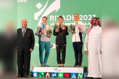 Cheong Min (tengah) merangkul pingat emas dalam acara kombinasi nanquan dan nandao wanita pada temasya Sukan Tempur Dunia 2023 di King Saud University di Riyadh, Arab Saudi, pada Ahad.