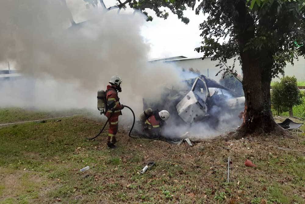 Anggota bomba memadamkan kebakaran kereta jenis Nissan Almera yang terbabas melanggar pokok.