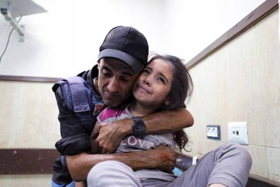 Seorang wartawan warga Palestin memeluk anak buahnya yang cedera susulan serangan tentera rejim Zionis Israel ke atas rumahnya di kem pelarian Nusseirat, Semenanjung Gaza. - Foto: AP