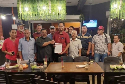 Tarmizi (tiga dari kiri) menerima borang keahlian baharu daripada Abdul Mukmin bersama ahli UMNO yang lain dalam satu majlis di sebuah restoran di sini pada Jumaat.