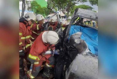 Anggota bomba mengeluarkan mayat seorang pemandu yang rentung selepas kereta dipandunya terbabas dan melanggar sebatang pokok di Kawasan Perindustrian Pasir Gudang, Pasir Gudang pada Isnin.