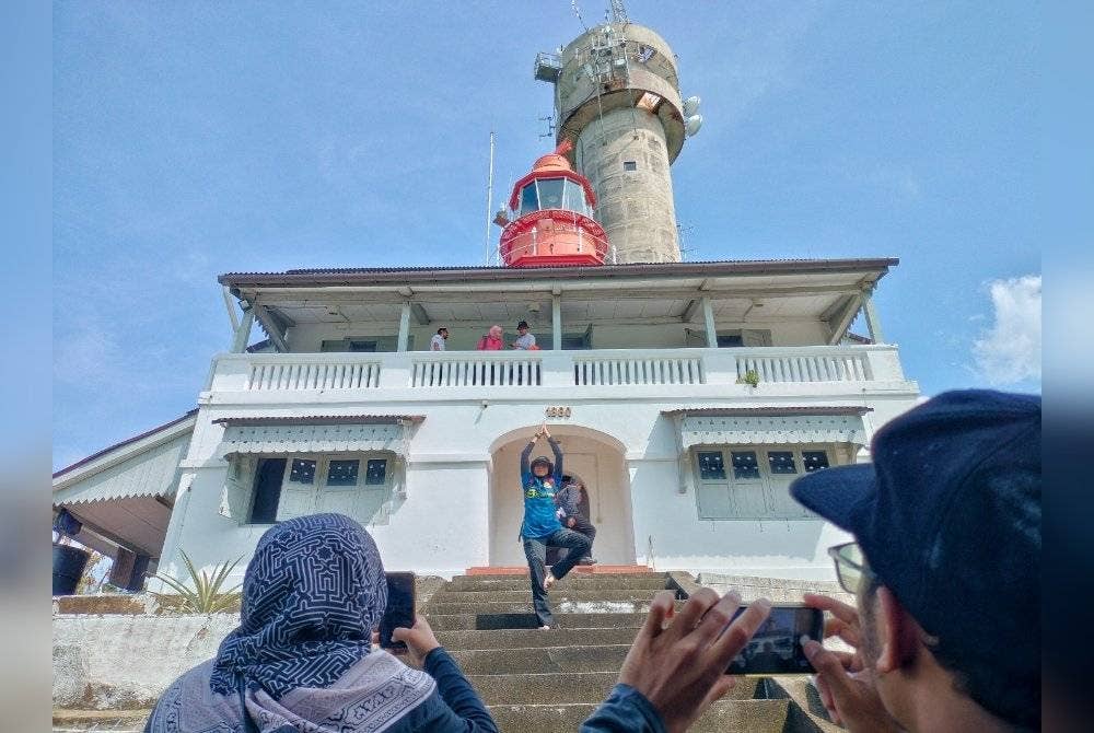 Pengunjung tidak melepaskan peluang bergambar di Rumah Api yang dibina pada 1880 di Pulau Undan, Melaka.