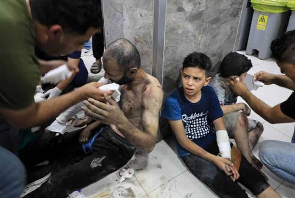 Antara rakyat Palestin yang cedera terpaksa duduk di lantai jabatan Kecemasan Hospital Al-Shifa sementara menanti masa untuk menerima rawatan dariada doktor. - Gambar AP