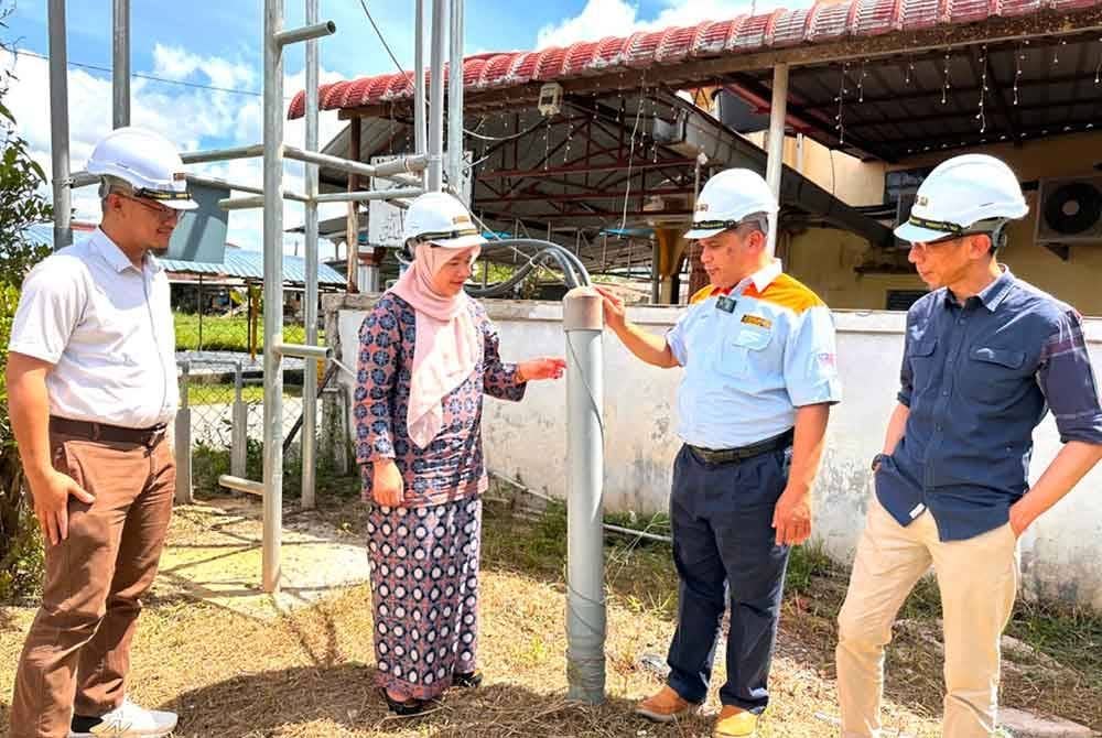 Zulkifli (dua, kanan) dan Noor Ain (dua, kiri) melihat telaga tiub yang dibina oleh pihak-pihak berkenaan.
