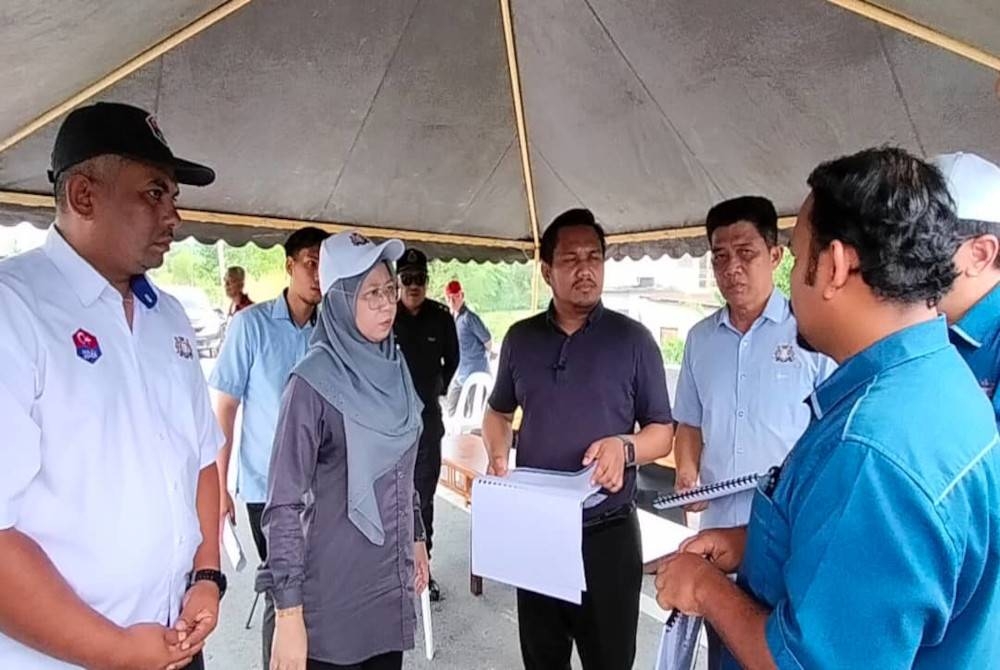 Mohmad Fazli (tengah) berbincang mengenai Projek Jalan Kampung Rahmat dan Estet Sri Gading pada Selasa.