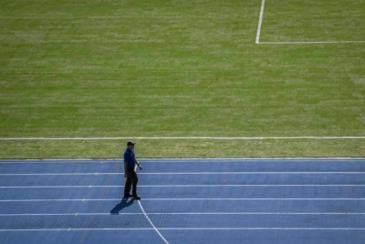 Seorang lelaki berjalan di padang yang baru ditukar kepada jenis rumput Zeon Zoysia pada Perasmian Padang Stadium Nasional baru-baru ini. - Foto Bernama