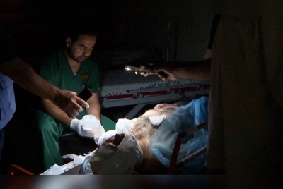 Seorang doktor terpaksa merawat pesakit menggunakan lampu telefon bimbit berikutan kebanyakan hospital di Gaza semakin kehabisan bekalan bahan api untuk beroperasi. - Foto Agensi