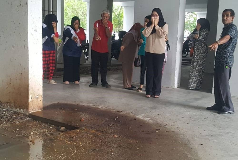 Penduduk Pangsapuri Desa Melayu, Johor Bahru menunjukkan sisa kumbahan dari tangki septik yang melimpah.
