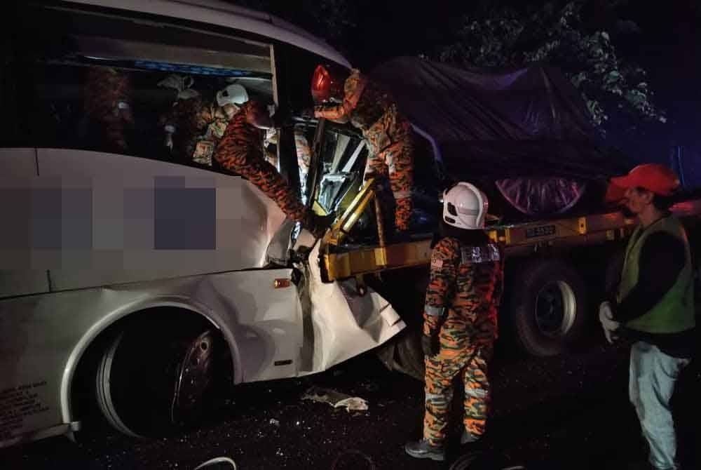 Pasukan bomba dan penyelamat membantu mengeluarkan mangsa yang tersepit. - Foto Polis Daerah Alor Gajah
