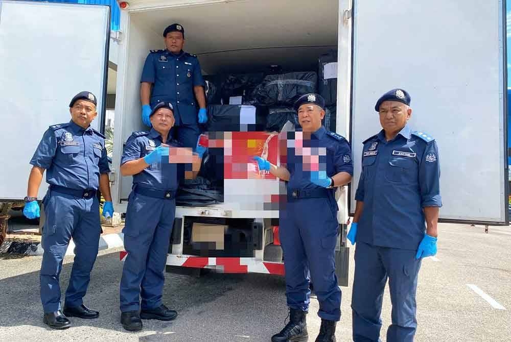 Wan Jamal Abdul Salam (dua,kanan) menunjukkan rokok yang diseludup menggunakan lori jenis bonded di Melor, Kota Bharu pada 18 Oktober lalu.